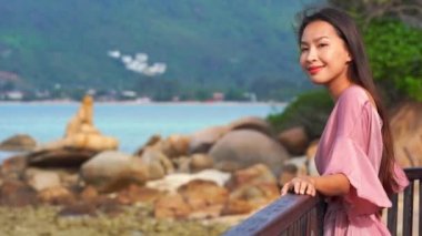 Güzel Asyalı kadının yaz tatilinde deniz kıyısında dinlendiği görüntüler.