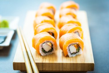 Somon Balık et suşi roll maki ahşap plaka üzerinde