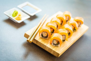 Somon Balık et suşi roll maki ahşap plaka üzerinde