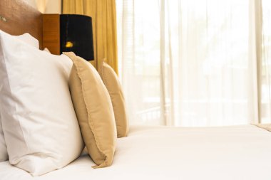 Yatak üzerinde güzel konforlu lüks beyaz yastık ve battaniye Dec