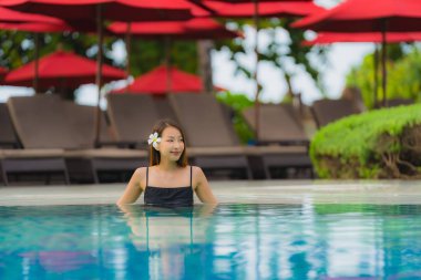 Portre genç asyalı kadın rahatla gülümseme açık yüzmek etrafında mutlu