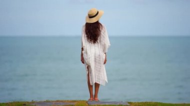 Güzel Asyalı kadının yaz tatilinde deniz kıyısında dinlendiği görüntüler.
