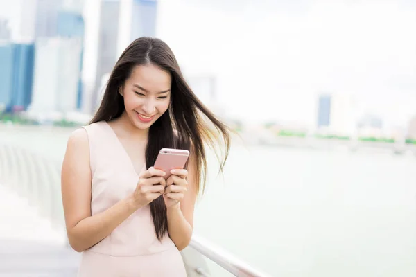 Mujer asiática usando teléfono inteligente o móvil para hablar o texto — Foto de Stock