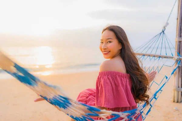 Porträtt vacker ung asiatisk kvinna sitter på hängmattan med — Stockfoto
