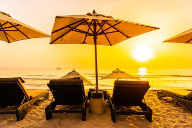 Şemsiye ve güzel plaj ve deniz gündoğumu, sandalyeye tim