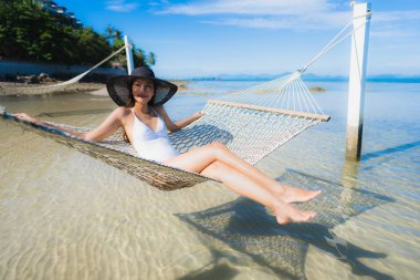 Portre güzel genç Asyalı kadın etrafında hamak üzerinde oturuyor s