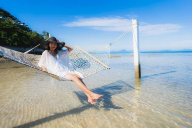 Portre güzel genç Asyalı kadın etrafında hamak üzerinde oturuyor s