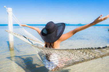 Portre güzel genç Asyalı kadın etrafında hamak üzerinde oturuyor s