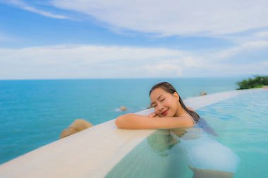 Portre genç asyalı kadın rahatla gülümseme açık yüzmek etrafında mutlu