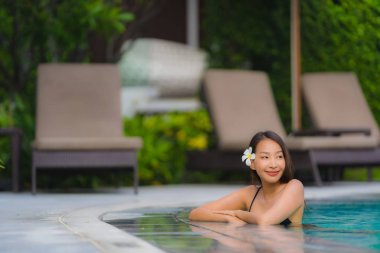 Portre genç asyalı kadın rahatla gülümseme açık yüzmek etrafında mutlu