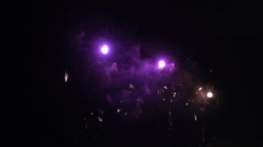 Gece gökyüzünde patlayan havai fişeklerin yakın çekim görüntüleri.