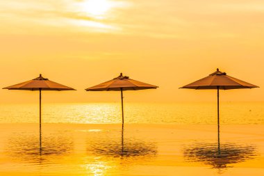 Şemsiye ve sandalye yüzme havuzu yakınında deniz okyanus plaj