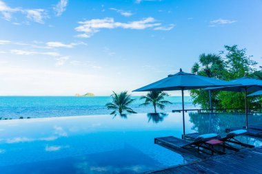 Şemsiye ve güzel lüks açık yüzme havuzu etrafında sandalye