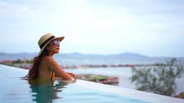 Güzel Asyalı bir kadının oteldeki havuzda dinlenirken çekilmiş görüntüleri.