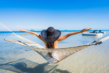 Portre güzel genç Asyalı kadın etrafında hamak üzerinde oturuyor s