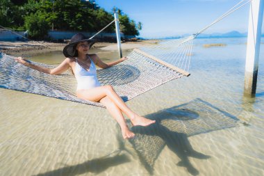 Portre güzel genç Asyalı kadın etrafında hamak üzerinde oturuyor s