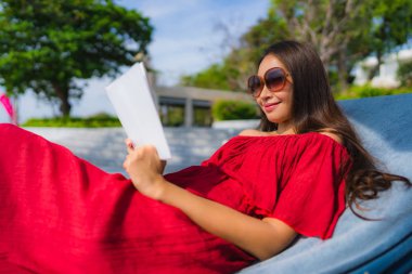 Portre güzel genç Asya kadın okuma kitap içinde yüzme Po