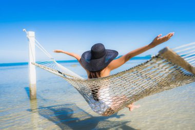 Portre güzel genç Asyalı kadın etrafında hamak üzerinde oturuyor s