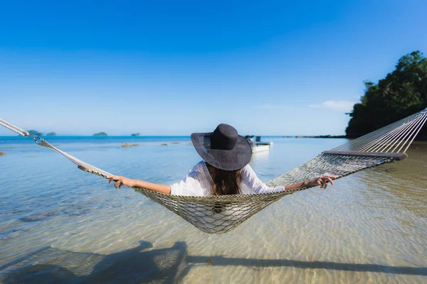 Portre güzel genç Asyalı kadın etrafında hamak üzerinde oturuyor s