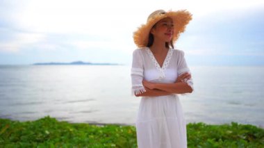 Güzel Asyalı kadının yaz tatilinde deniz kıyısında dinlendiği görüntüler.