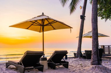 Şemsiye ve güzel plaj ve deniz gündoğumu, sandalyeye tim