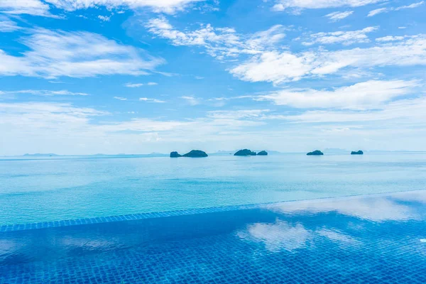 Beautiful outdoor swimming pool with sea ocean on white cloud bl — Stock Photo, Image