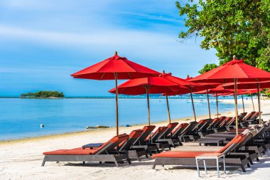 Şemsiye sandalye ile güzel açık tropikal plaj deniz Okyanusu