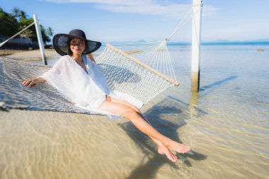 Portre güzel genç Asyalı kadın etrafında hamak üzerinde oturuyor s