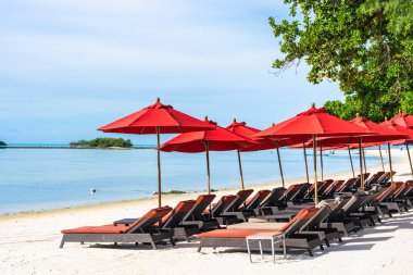 Şemsiye sandalye ile güzel açık tropikal plaj deniz Okyanusu