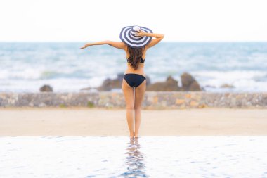 Portre güzel genç Asyalı kadın yüzme etrafında bikini giymek