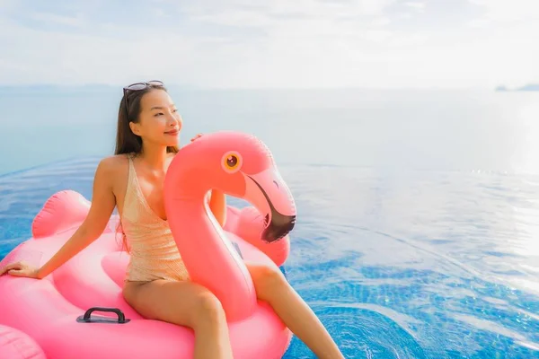 Portret jonge Aziatische vrouw op opblaasbare float Flamingo rond o — Stockfoto