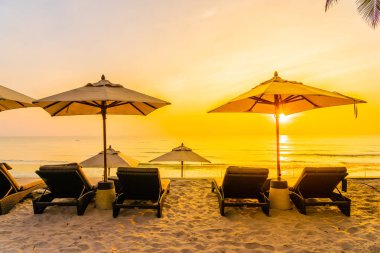 Şemsiye ve güzel plaj ve deniz gündoğumu, sandalyeye tim