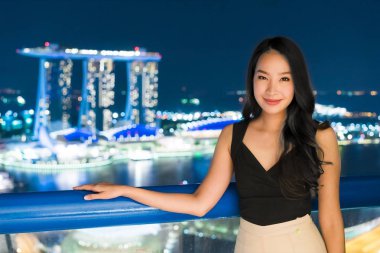 Güzel Asyalı kadınlar gülümseme ve mutlu Singapur şehir manzaralı