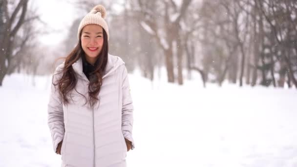 Metraje Hermosa Mujer Asiática Invierno Chaqueta Mirando Cámara Bajo Nieve — Vídeos de Stock