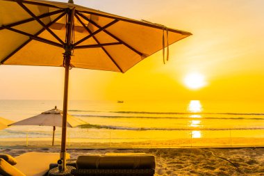 Şemsiye ve güzel plaj ve deniz gündoğumu, sandalyeye tim