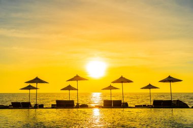 Şemsiye ve sandalye resort hotel leis için yüzme havuzunda çevresinde