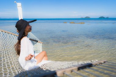 Portre güzel genç Asyalı kadın etrafında hamak üzerinde oturuyor s