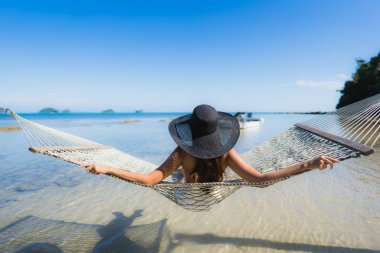 Portre güzel genç Asyalı kadın etrafında hamak üzerinde oturuyor s