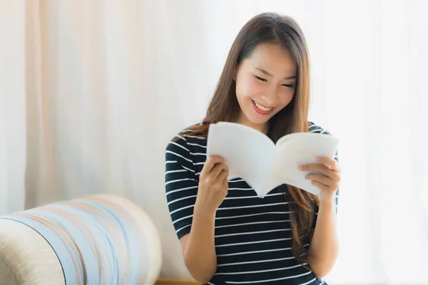 Retrato hermosa joven asiática mujer leyendo libro en en sofá en — Foto de Stock