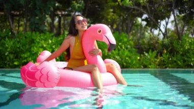 Güzel Asyalı bir kadının oteldeki havuzda dinlenirken çekilmiş görüntüleri.