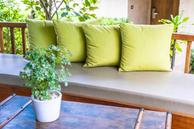 Koltuk koltuğu üzerinde yastık ile masa dekorasyonu vazo bitki