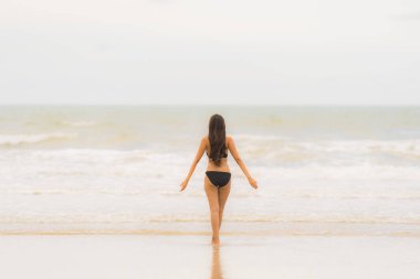Portre güzel genç Asyalı kadın plaj se üzerinde bikini giymek