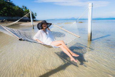 Portre güzel genç Asyalı kadın etrafında hamak üzerinde oturuyor s