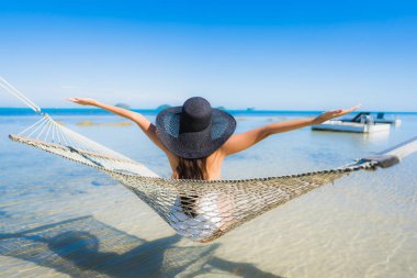 Portre güzel genç Asyalı kadın etrafında hamak üzerinde oturuyor s
