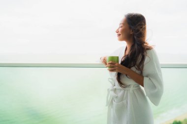 Güzel Portre genç Asyalı kadınlar outdo kahve fincanı tutan