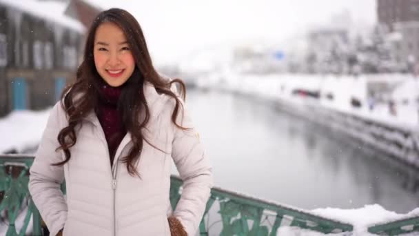 Metraje Hermosa Mujer Asiática Invierno Chaqueta Mirando Cámara Bajo Nieve — Vídeos de Stock