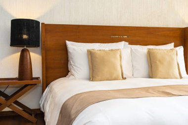 Yatak üzerinde güzel konforlu lüks beyaz yastık ve battaniye Dec