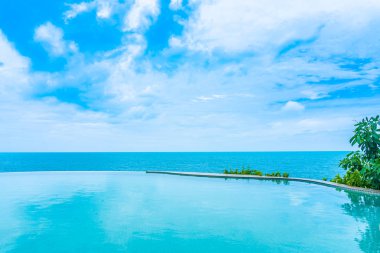 Tatil tatil ve seyahat için deniz okyanusu manzarası ve beyaz bulut mavi gökyüzü ile otel beldesinde güzel açık sonsuzluk yüzme havuzu