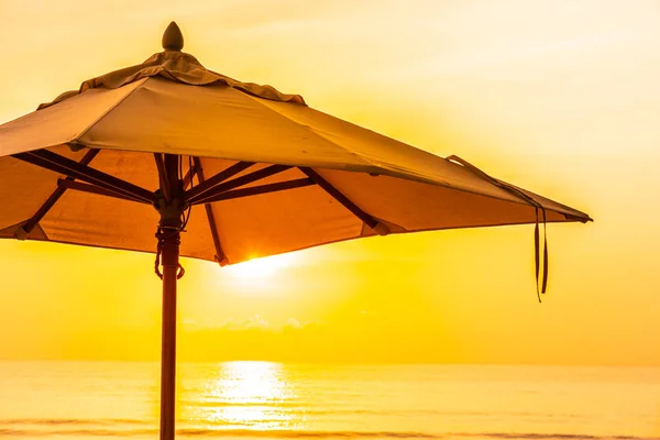 Napernyő és a gyönyörű tengerpart és a tenger napkeltekor szék tim — Stock Fotó