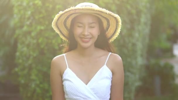 Filmaufnahmen Einer Schönen Asiatischen Frau Mit Strohhut Vor Grünen Blättern — Stockvideo